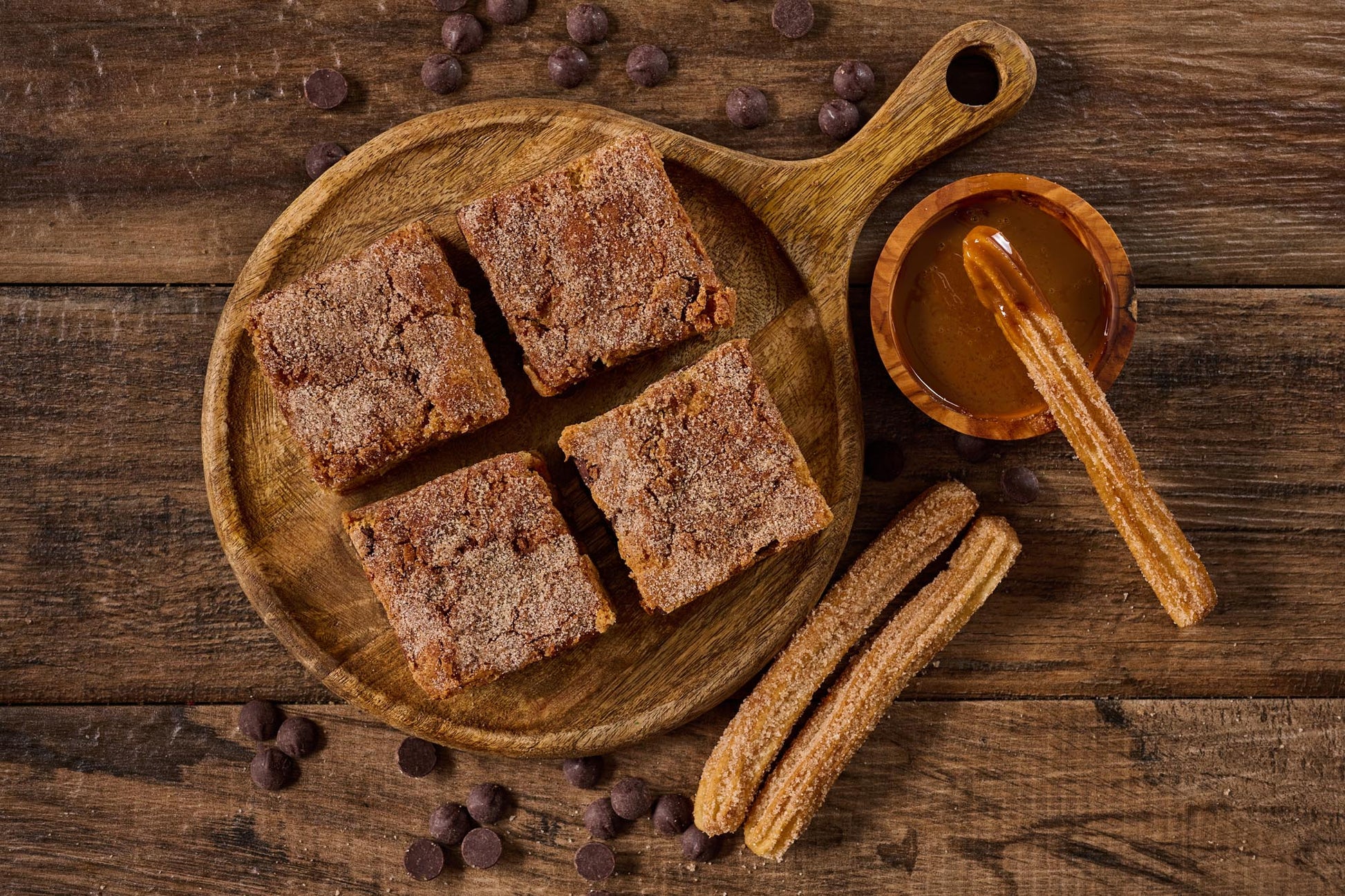 Churro Dulce de Leche Blondie with buttery cinnamon blondie base, swirled with dulce de leche, Ghirardelli dark chocolate chips, and topped with cinnamon sugar for a rich, caramelized treat