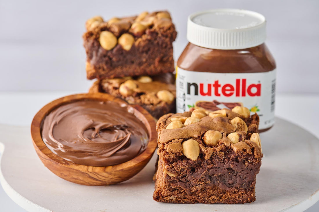 Nutella and Hazelnut Brownie with fudgy cocoa base, swirled with Nutella, crunchy hazelnut chunks, and topped with a Nutella drizzle and whole hazelnuts for a rich, indulgent treat