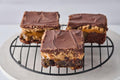 Millidough Million Dollar Cookie Dough Brownie with fudgy brownie base, caramel, homemade cookie dough, chocolate chips, and melted chocolate topping