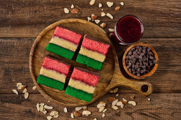 Italian Rainbow Cookie with almond cake layers, raspberry jam, chocolate coating, and colorful confetti topping
