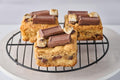 S'mores Blondie with rich buttery base, pockets of melted chocolate and gooey marshmallow, topped with graham cracker crumbs, toasted marshmallows, and Hershey's chocolate for a decadent s'mores treat.
